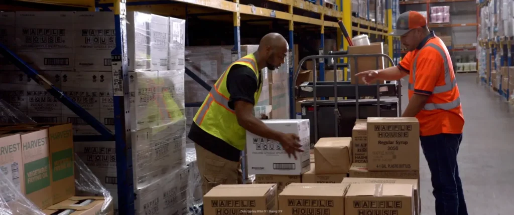 Cornbread Hustle workers carrying boxes at a warehouse